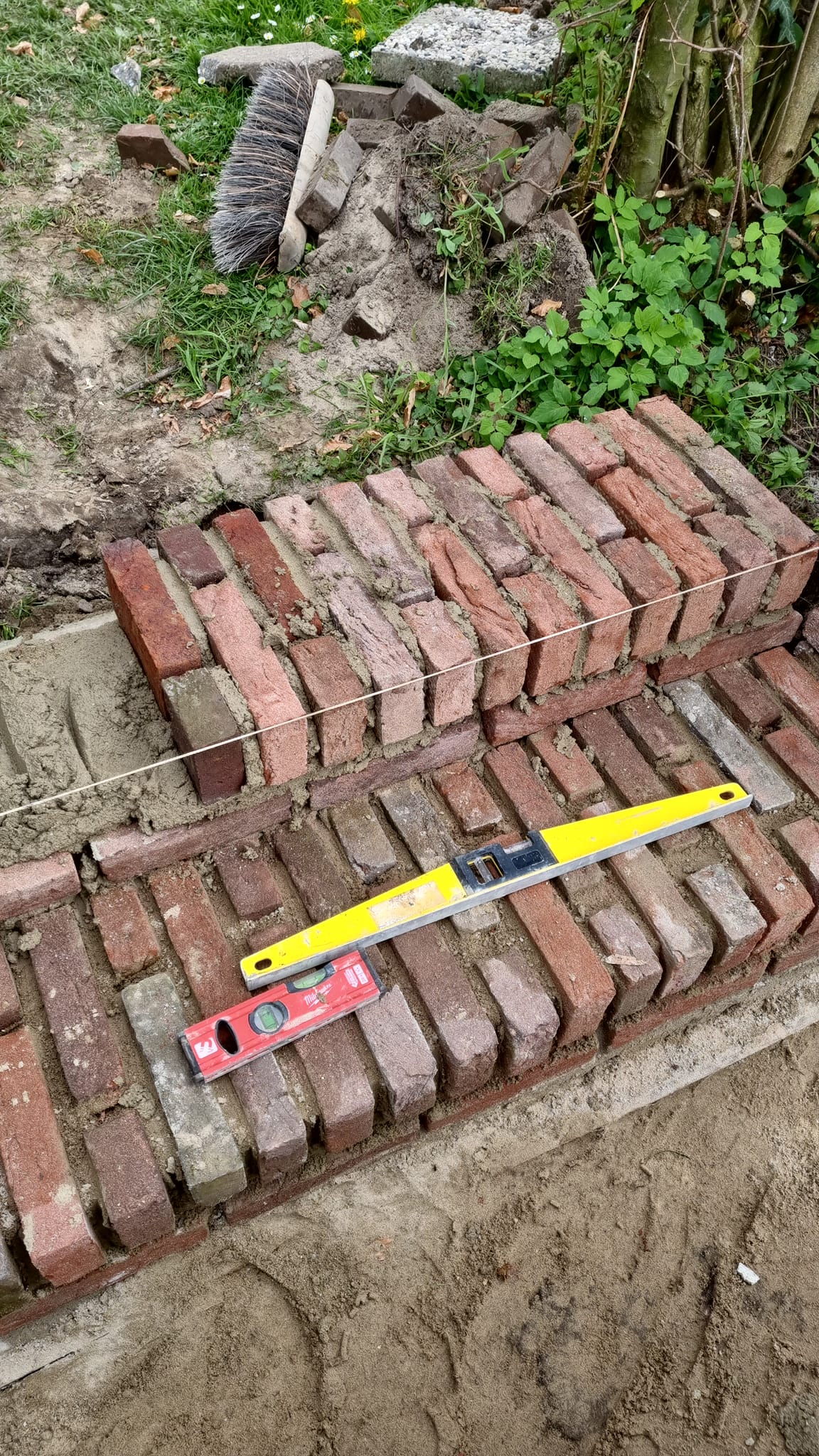 Afgewerkte tuinmuur langs beukenhaag